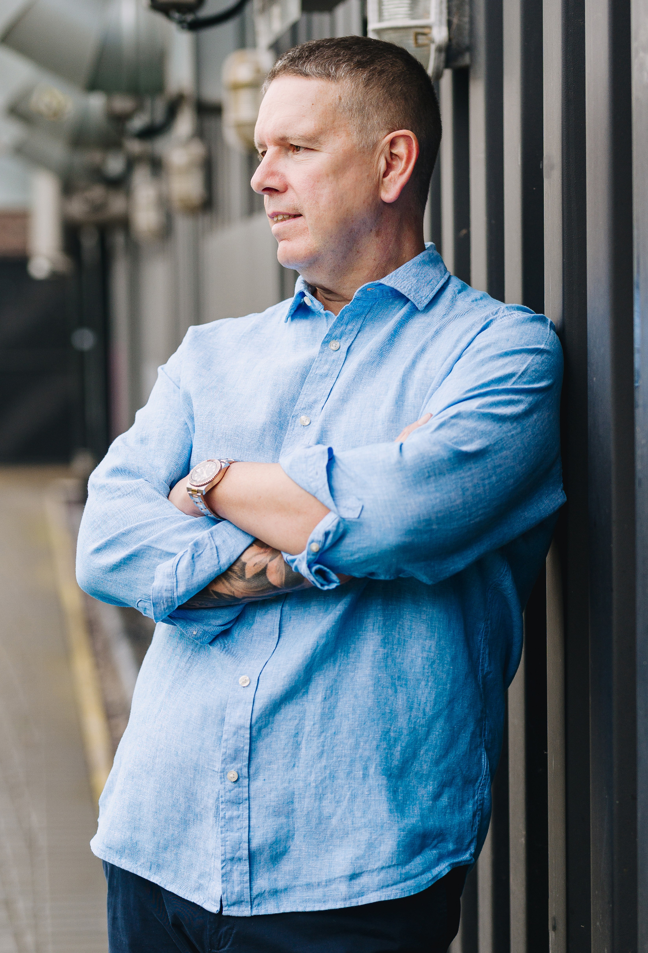 Steve Matthews leaning against railings, arms folded